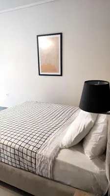 a bedroom with a bed with a black lamp on it at Ermou Downtown Suites by Athens Urban Retreat in Athens