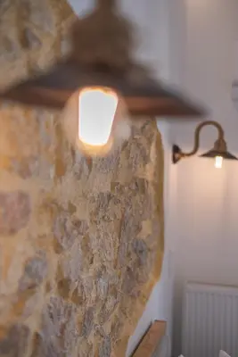 a light attached to a stone wall with a candle at 2bdroom Plaka Apartment in Athens