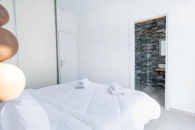 a white bedroom with a white bed and a brick wall at 2bdroom Plaka Apartment in Athens