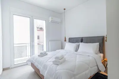 a white bedroom with a large bed with towels on it at 2bdroom Plaka Apartment in Athens