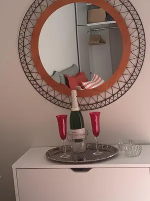 a mirror on a table with two glasses and a bottle of wine at Studio Next to Acropolis in Athens