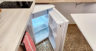 an empty refrigerator with its door open in a kitchen at Kallithea Gold Apartment greendom in Athens