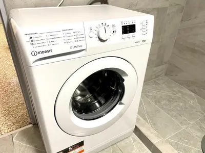 a white washing machine sitting in a room at Kallithea Gold Apartment greendom in Athens