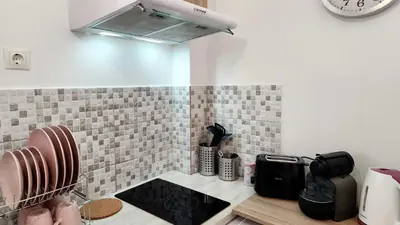 a kitchen with a counter with a stove and a clock at Kallithea Gold Apartment greendom in Athens