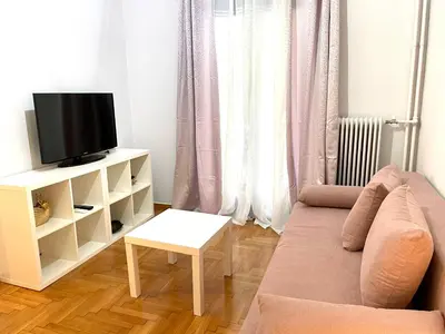 a living room with a couch and a tv at Kallithea Gold Apartment greendom in Athens