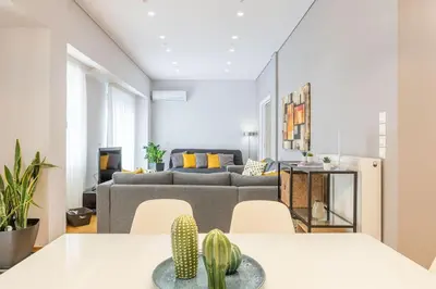 a living room with two tables and a couch at The HostMaster Cosmopolitan Downtown Scent in Athens