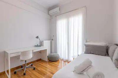 a white bedroom with a desk and a bed at The HostMaster Cosmopolitan Downtown Scent in Athens