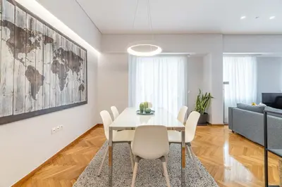 a dining room with a white table and chairs at The HostMaster Cosmopolitan Downtown Scent in Athens