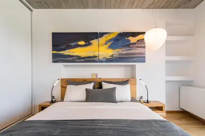 a bedroom with a bed with a painting above it at The HostMaster Skyline Pool Oasis Penthouse in Athens