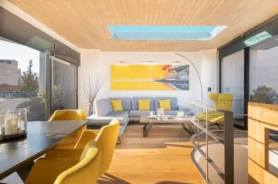 a living room with a table and yellow chairs at The HostMaster Skyline Pool Oasis Penthouse in Athens