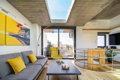 a living room with a couch and a table at The HostMaster Skyline Pool Oasis Penthouse in Athens
