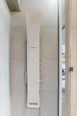 a glass shower door with a white wall at The HostMaster Skyline Pool Oasis Penthouse in Athens