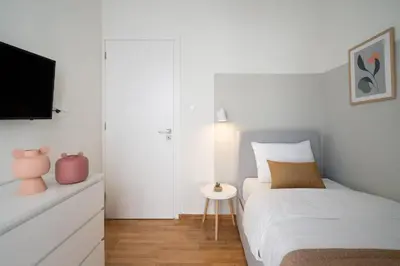 a white bedroom with a bed and a tv at Deluxe 4 Bedrooms Apartment in Athens Center in Athens