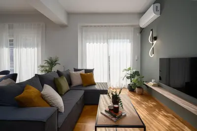 a living room with a blue couch and a table at Deluxe 4 Bedrooms Apartment in Athens Center in Athens