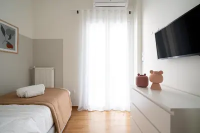 a bedroom with a bed and a flat screen tv at Deluxe 4 Bedrooms Apartment in Athens Center in Athens