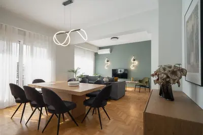 a dining room and living room with a table and chairs at Deluxe 4 Bedrooms Apartment in Athens Center in Athens