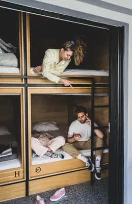 a group of three people sleeping in bunk beds at Mosaikon Glostel in Athens