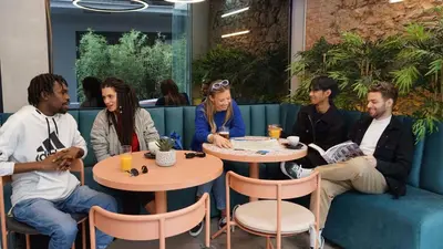 a group of people sitting at tables in a restaurant at Mosaikon Glostel in Athens