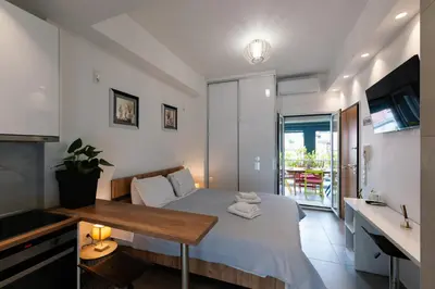 a bedroom with a bed and a table and a sink at Modern studio apartment A in Athens