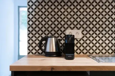 a black and silver coffee pot on a wooden table with a wall at Modita Boutique Apartments in Athens