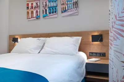 a bedroom with a white bed and two paintings on the wall at Exarchia House Project in Athens