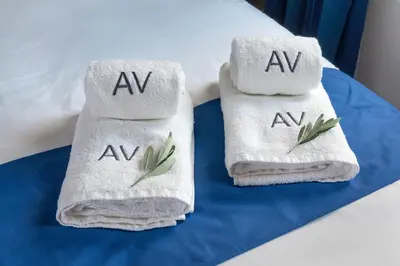two towels with leaves on them on a bed at Exarchia House Project in Athens