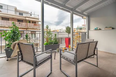 a patio with two chairs and a table on a balcony at Exarchia House Project in Athens
