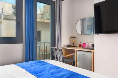 a bedroom with a bed and a desk and a window at Exarchia House Project in Athens