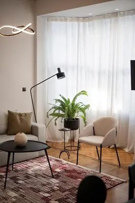 a living room with a couch and a table and a plant at JUST KOLONAKI in Athens