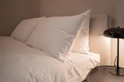 a white bed with white pillows on top of it at JUST KOLONAKI in Athens