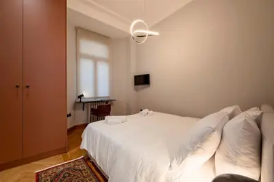 a bedroom with a white bed with a ceiling fan at JUST KOLONAKI in Athens