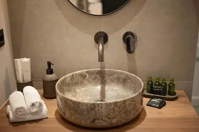 a bathroom sink with a large stone bowl sink at JUST KOLONAKI in Athens