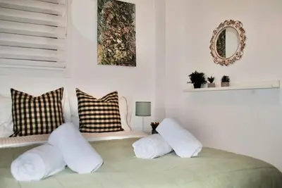 a room with a bed with pillows and a mirror at GPK Lux 2BR - 7 min walking to Acropolis in Athens
