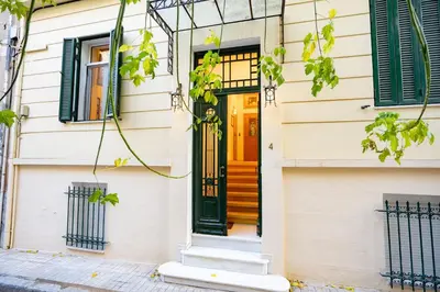 a house with a yellow door and green shutters at Acropolis metro st 3 bedrms 6 pers maisonette by MPS in Athens