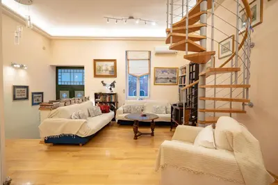 a living room with couches and a spiral staircase at Acropolis metro st 3 bedrms 6 pers maisonette by MPS in Athens