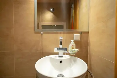 a white sink in a bathroom with a mirror at Acropolis metro st 3 bedrms 6 pers maisonette by MPS in Athens