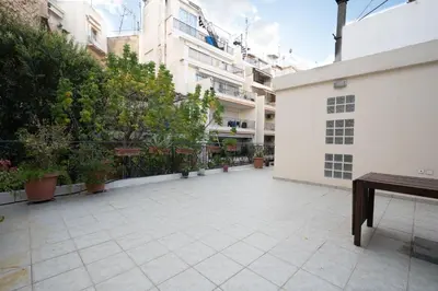 a courtyard with potted plants and a white building at Acropolis metro st 3 bedrms 6 pers maisonette by MPS in Athens