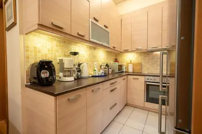 a kitchen with wooden cabinets and a counter top at Acropolis metro st 3 bedrms 6 pers maisonette by MPS in Athens
