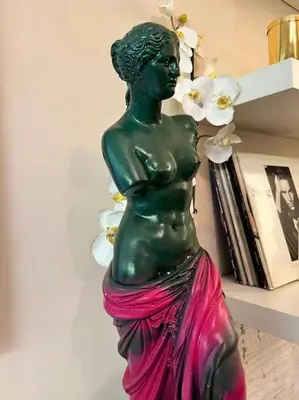 a green statue of a woman in a pink skirt at Lux Beach Apartment in Vari