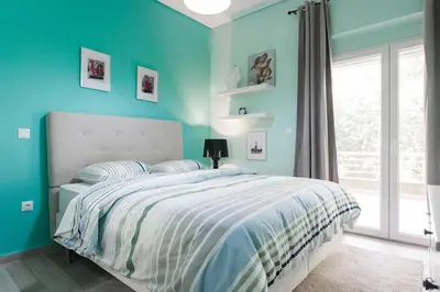 a blue bedroom with a bed and a window at Lux Beach Apartment in Vari
