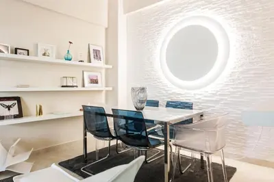 a dining room with a glass table and blue chairs at Lux Beach Apartment in Vari