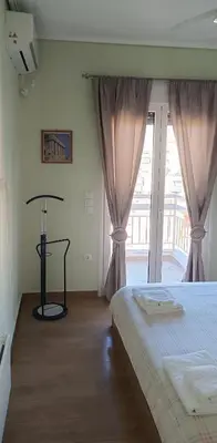 a bedroom with a bed and a large window at Overlooking the Acropolis in Athens