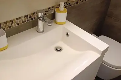a white sink in a bathroom with a toilet at Overlooking the Acropolis in Athens