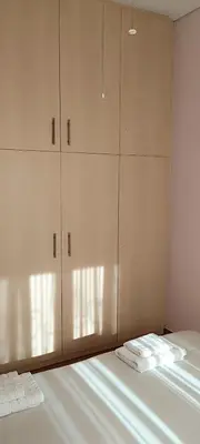 a bedroom with white cabinets and white towels on a bed at Overlooking the Acropolis in Athens