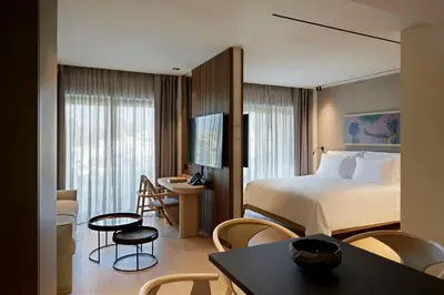 a hotel room with a bed and a table and chairs at Dusit Suites Hotel Athens in Athens