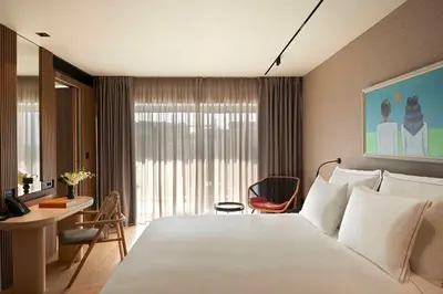 a hotel room with a large bed and a desk at Dusit Suites Hotel Athens in Athens