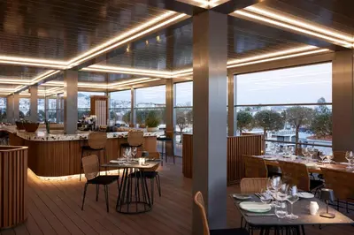 a restaurant with tables and chairs and large windows at Dusit Suites Hotel Athens in Athens