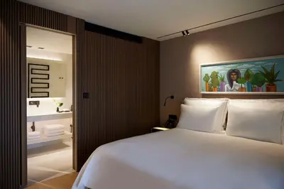 a bedroom with a white bed and a painting on the wall at Dusit Suites Hotel Athens in Athens