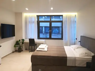 a bedroom with a bed and a desk and a window at Evripidou Experience - The Suite in Athens