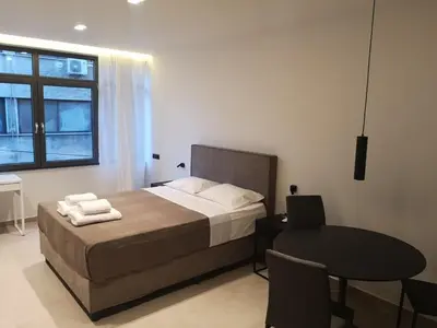 a bedroom with a bed and a table with a laptop at Evripidou Experience - The Suite in Athens